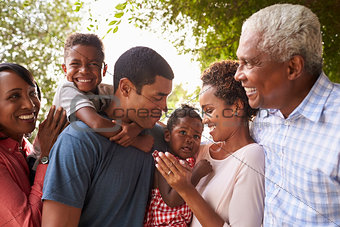 Multi generation black family look at each other in garden