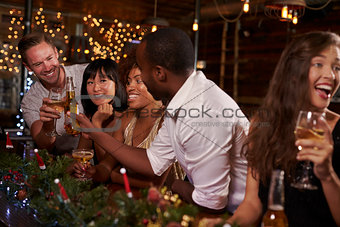 Friends enjoying a Christmas party at a bar making a toast