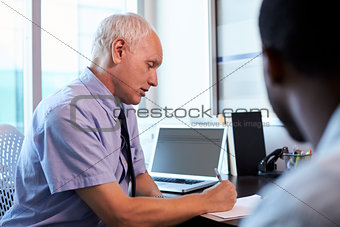 Doctor In Consultation With Male Patient In Office
