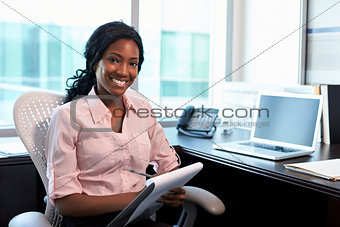 Portrait Of Female Doctor Working In Office
