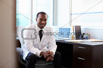 Portrait Of Doctor Wearing White Coat In Office