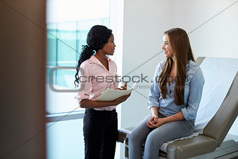 Female Doctor Meeting With Teenage Patient In Exam Room