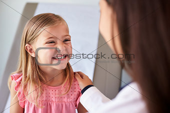 Pediatrician In White Coat With Child In Exam Room