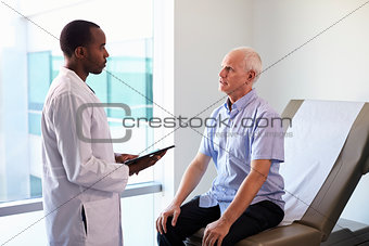 Doctor Meeting With Mature Male Patient In Exam Room