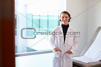 Portrait Of Female Doctor Wearing White Coat In Exam Room