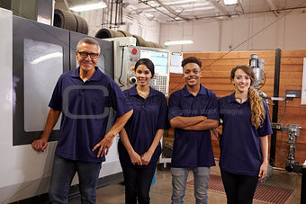 Portrait Of Engineer Training Apprentices On CNC Machine