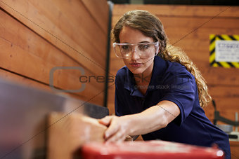 Female Carpenter Using Plane In Woodworking Woodshop