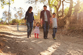 Mixed race family walking on rural path, front view