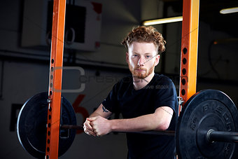 Portrait Of Young Man In Gym Lifting Weights On Barbell