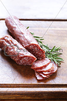 salami sausage with rosemary on a wooden board