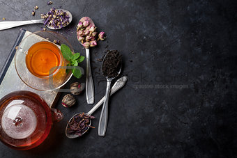 Tea cup and assortment of dry tea in spoons