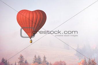 d air balloon in the shape of a heart flying in foggy forest