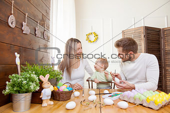 Easter concept. Happy mother and father preparing home decoration with their child for Easter holidays
