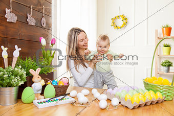 Happy Mother and her cute child celebrating Easter at home