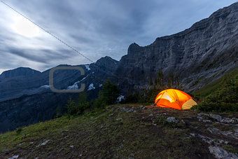 Illuminated tent camping on ridgeline of mountain