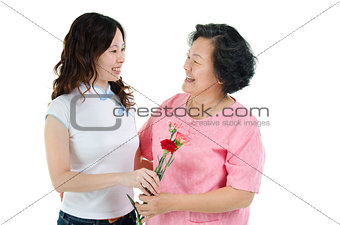 Mother and daughter holding carnation flower and smiling