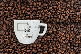 cup with the inscription on the background of coffee beans