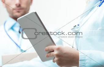 doctors thinking about exam's data with a tablet