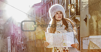 elegant tourist woman in Venice, Italy in winter with map