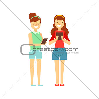 Two Girls Tooking At Their Tablets Standing, Person Being Online All The Time Obsessed With Gadget