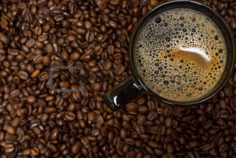 coffee beans background and black cup with hot drink