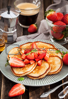 Homemade delicious pancakes served with fresh strawberries and h