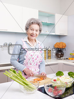 senior woman preparing meal in kitchen