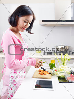 asian housewife preparing meal in kitchen