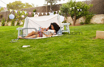 Mother And Daughter Playing In Home Made Garden Den