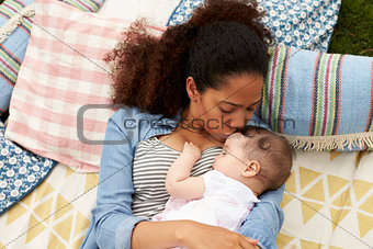 Overhead View Of Mother With Baby Relaxing On Rug In Garden