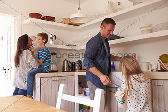 Children Helping Parents In Kitchen With Chores