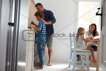 Father And Son In Kitchen Making Meal Together