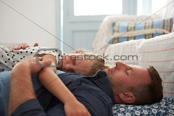 Father And Daughter Lying On Floor Asleep Together