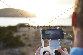 Close Up Of Man Flying Drone Over Coastal Landscape