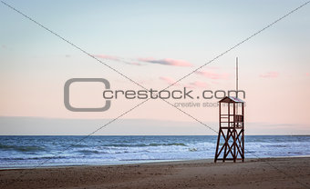 Beach sunrise with vintage lifeguard wood tower