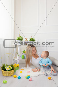 Delighted mother and her child enjoying the Easter egg hunt at home