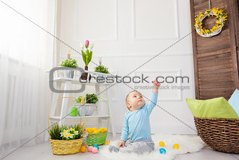 Easter egg hunt. Adorable child playing with Easter eggs at home