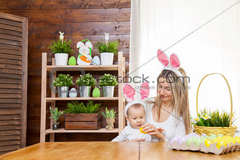 Happy mother and her cute child wearing bunny ears, getting ready for Easter 