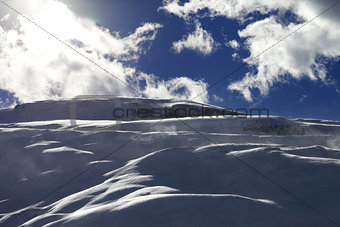 Off-piste slope during blizzard and sunlight blue sky with cloud