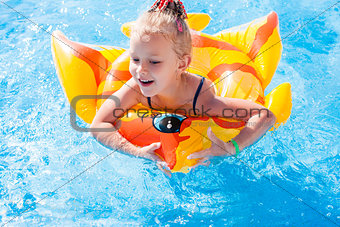 Cute happy little girl having fun in swimming pool