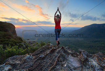Female fitness stretch to the sky mountain top valley scene