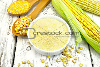 Flour corn in bowl with spoons on board