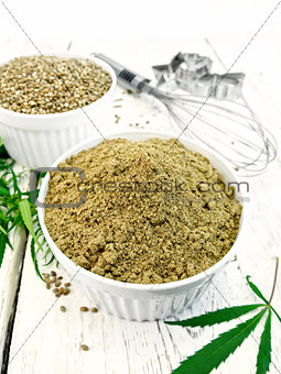 Flour hemp and grain in bowls with leaf on board