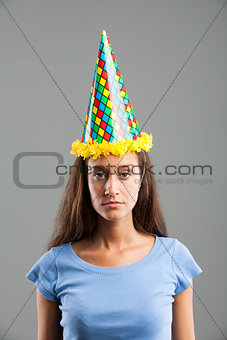 Woman looking with sadness while wearing party hat