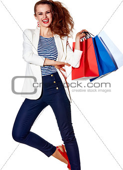Smiling young woman with shopping bags on white background