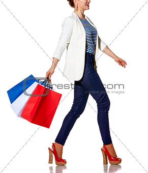 happy woman with French flag colours shopping bags going to side