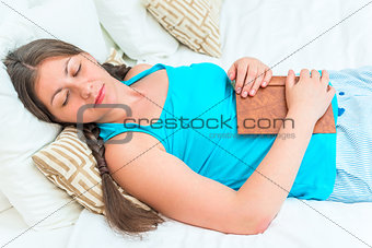 portrait of a girl asleep with a book in bed