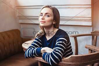 Portrait of smiling female hipster waiting for meeting with best friend while during coffee break in cafe. Grey background with copy space area for advertising content