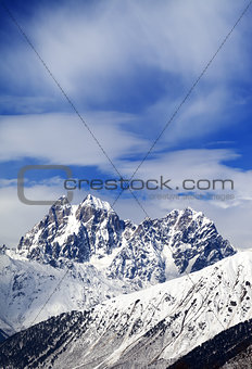 Mounts Ushba and Chatyn and blue sky with clouds in winter wind 