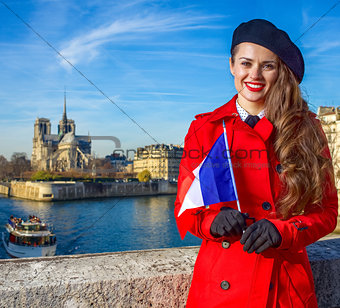 woman on embankment near Notre Dame de Paris with French flag